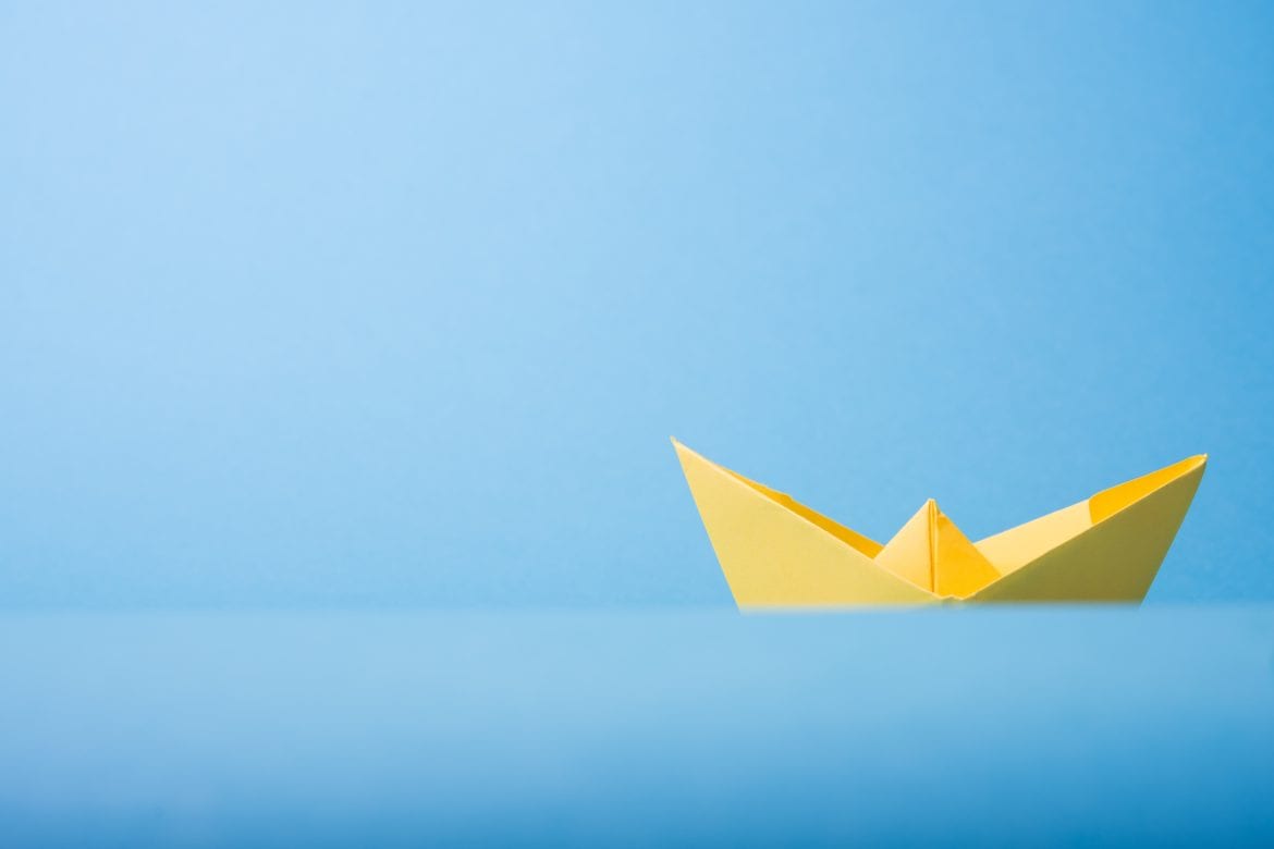 paper boat on blue background