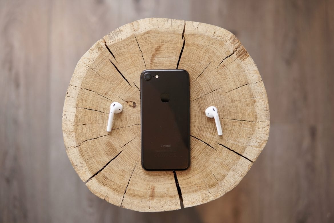phone and earbuds on log
