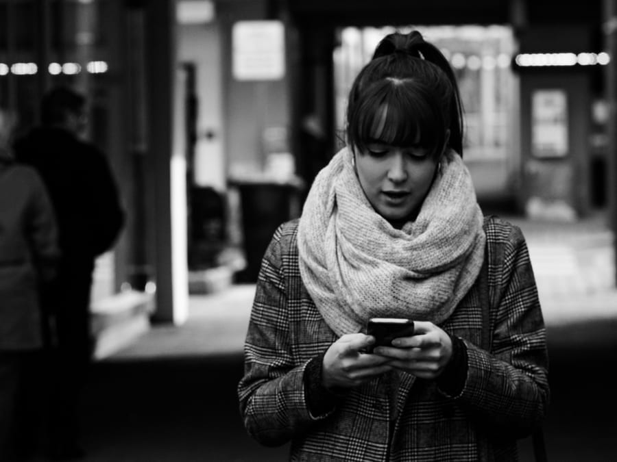 woman looking at smartphone wearing scarf